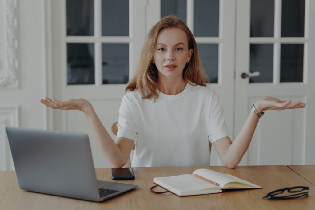 Confused woman at laptop weighing options, symbolizing how to choose the right dental marketing agency with Clear to Launch Dental Marketing