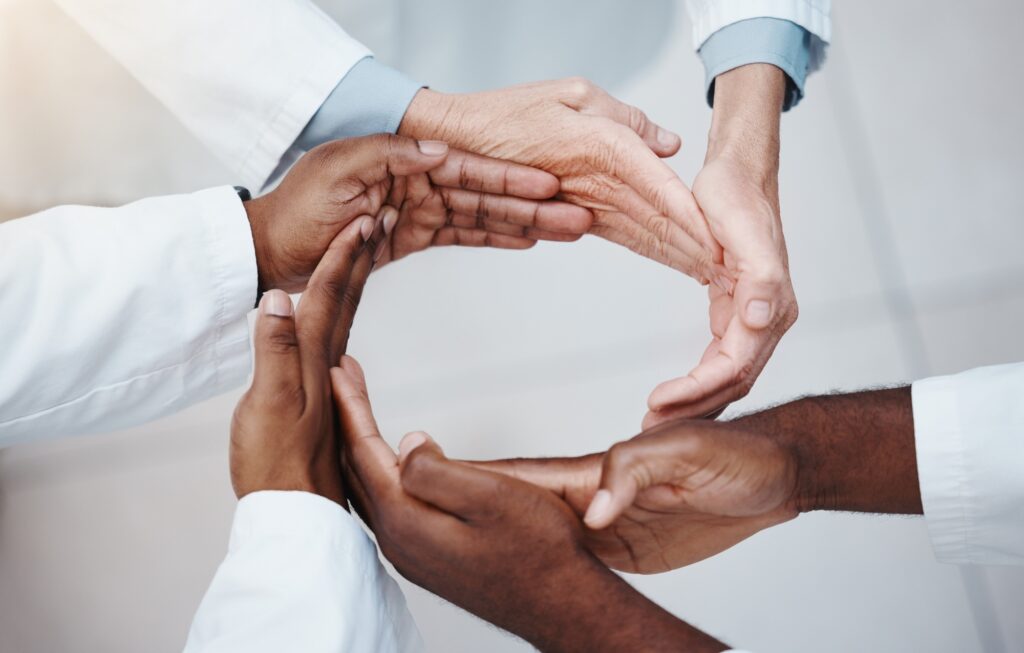 Diverse hands forming a circle symbolizing unity and trust, representing Clear to Launch Dental Marketing’s focus on building patient trust through testimonials and reviews