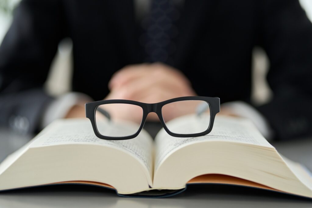 Eyeglasses resting on an open book symbolizing Clear to Launch Dental Marketing’s guide to essential dental marketing terms and their importance