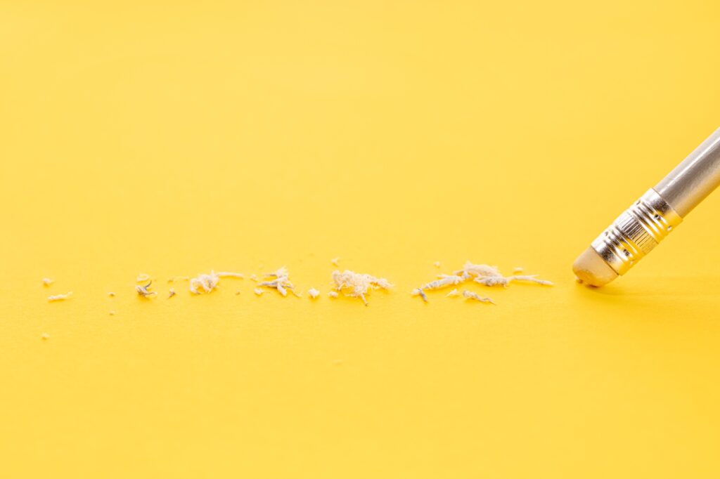 Pencil erasing on yellow background symbolizing common dental marketing mistakes and how to fix them
