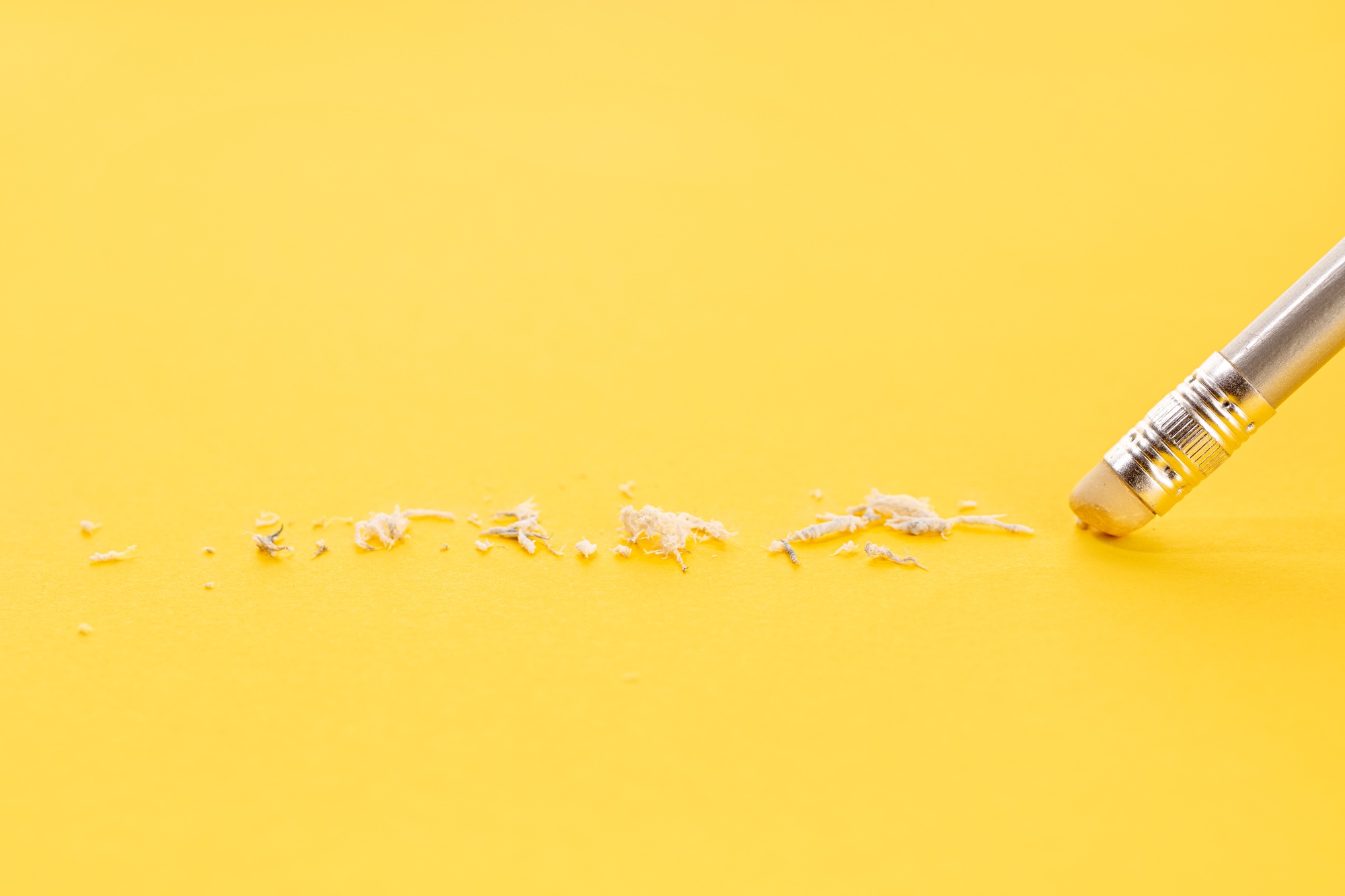 Pencil erasing on yellow background symbolizing common dental marketing mistakes and how to fix them
