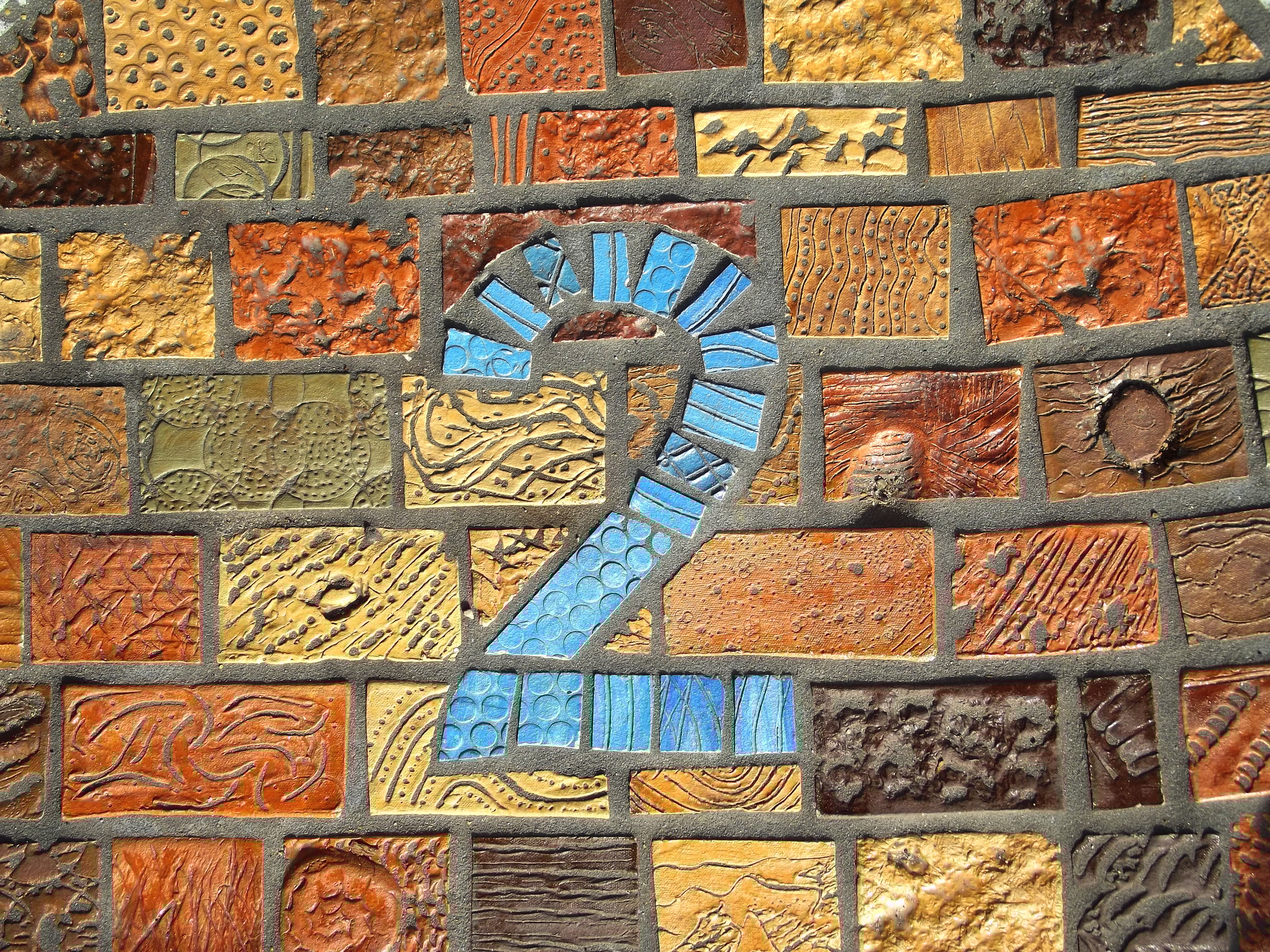 Blue number 2 on a colorful mosaic wall symbolizing Step 2 in Clear to Launch Dental Marketing’s modern dental marketing strategy