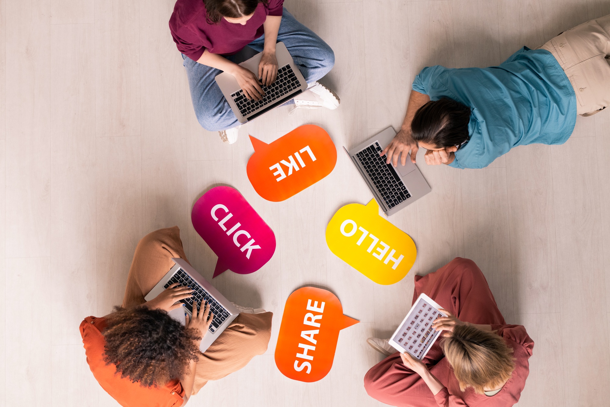 “Group of people on laptops surrounded by social media icons, representing Clear to Launch Dental Marketing’s guide to creating engaging dental social media content